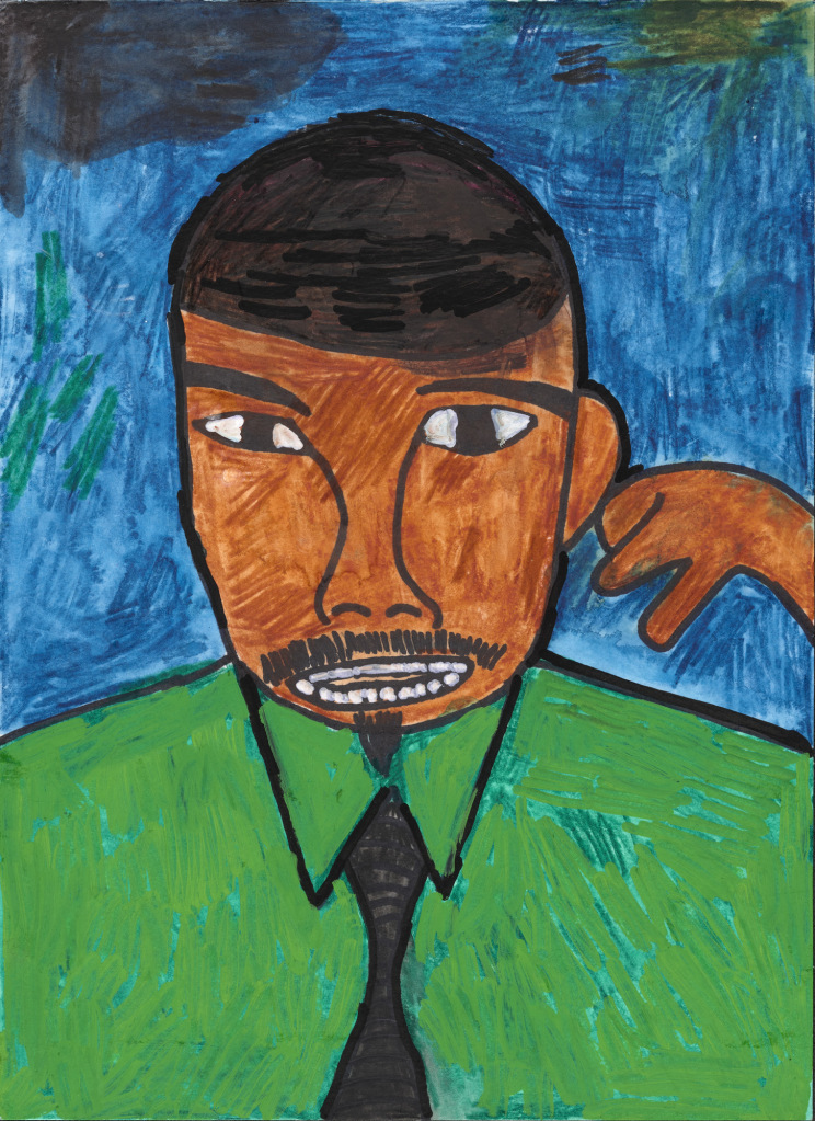 A smiling African American man with very short hair and a neat moustache signs and smiles. The blue background is almost the same color as his green shirt and draws attention to his face and hand.